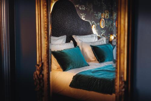 a mirror reflection of a bed with pillows at Madame C - Hôtel très particulier in Strasbourg