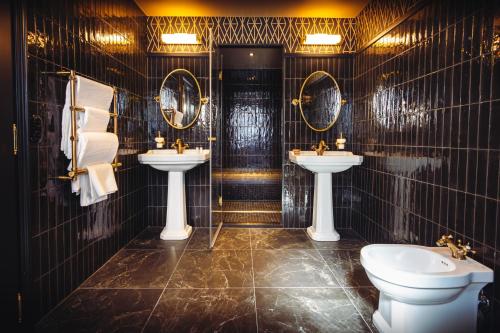 a bathroom with two sinks and two mirrors at Madame C - Hôtel très particulier in Strasbourg