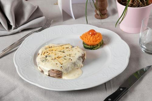 a white plate with food on a table at Hotel Granta Parey in Rhêmes-Notre-Dame