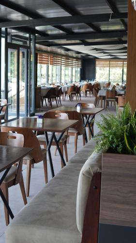 a restaurant with wooden tables and chairs and windows at Panorama Hotel & Spa in Kruševo