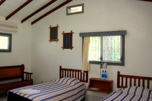 a bedroom with two beds and a window at La Casa de Don David in El Remate