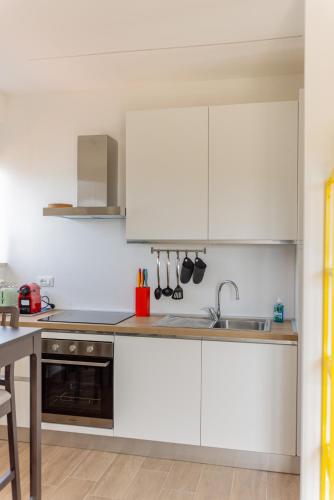 a kitchen with white cabinets and a sink at Il tuo rifugio vista mare DIMORA SABUCCHI in Pescara