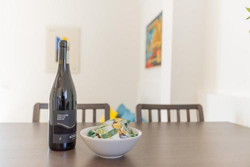 a bottle of wine and a bowl on a table at Il tuo rifugio vista mare DIMORA SABUCCHI in Pescara