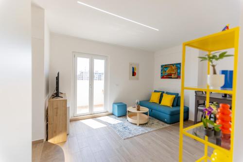 a living room with a blue couch and yellow pillows at Il tuo rifugio vista mare DIMORA SABUCCHI in Pescara