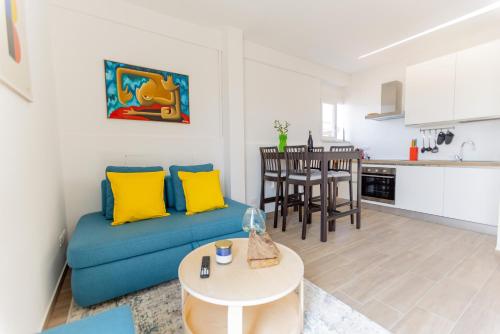 a living room with a blue couch and a kitchen at Il tuo rifugio vista mare DIMORA SABUCCHI in Pescara