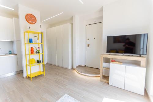 a living room with a tv and a yellow shelf at Il tuo rifugio vista mare DIMORA SABUCCHI in Pescara