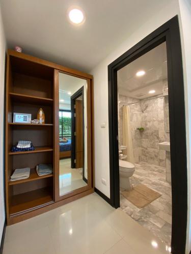 a bathroom with a walk in shower and a toilet at Rawai Beach - 1 BR Cozy Condo in Nai Harn Beach