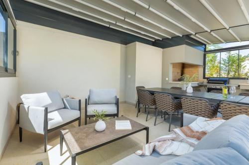 a living room with a couch and chairs and a table at Villa Philia by Villsy in Butkovići