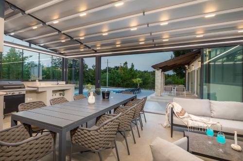 an outdoor patio with a table and chairs at Villa Philia by Villsy in Butkovići