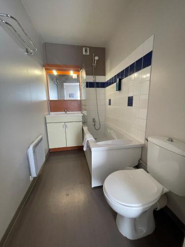 a bathroom with a toilet and a tub and a sink at City Résidence Nancy in Nancy