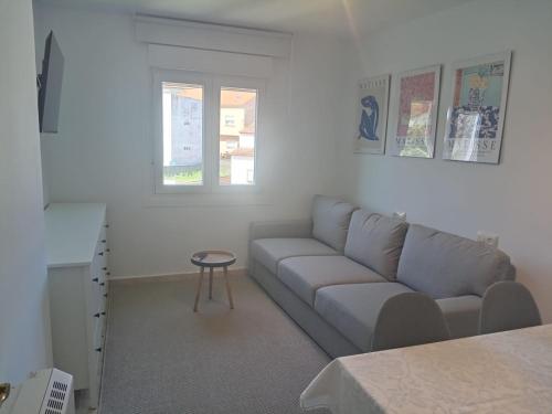 salon z kanapą i stołem w obiekcie Casa O Vento w mieście O Grove