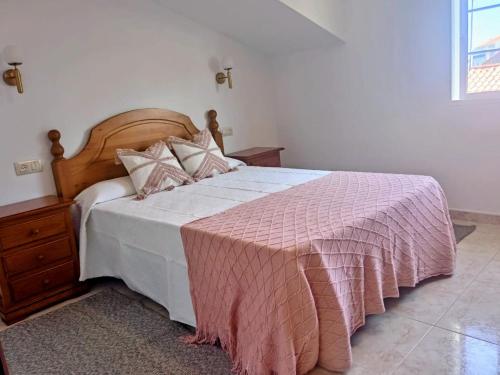 sypialnia z łóżkiem z różowym kocem w obiekcie Casa O Vento w mieście O Grove