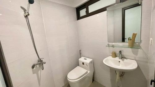 a white bathroom with a toilet and a sink at Era Apartment Khuc Thua Du in Hanoi