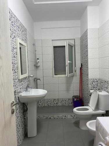 a bathroom with a toilet and a sink at Apartment in Primavera Residence in Fushë-Draç