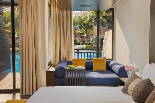 a hotel room with a couch and a view of a pool at Anantara The Palm Dubai Resort in Dubai