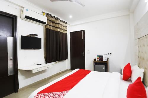 a bedroom with a large bed and a tv at Collection O Tipsyy Inn in Gurgaon