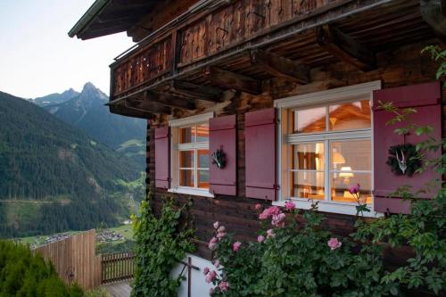a house with pink windows and flowers at Chalet "Altes Schulhaus" in Schruns-Tschagguns