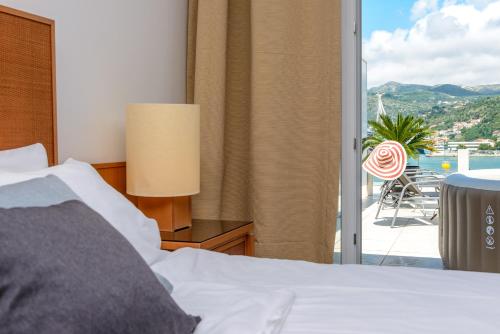 a bedroom with a bed and a sliding glass door at Adriatic Deluxe Apartments in Dubrovnik
