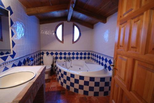 a blue and white bathroom with a tub and a sink at Alojamientos Rio Zumeta in El Morrion