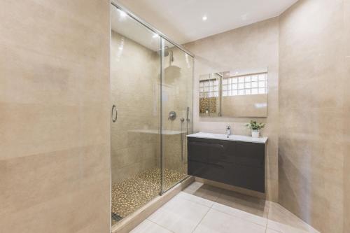 a bathroom with a glass shower with a sink and a toilet at Majestueux Appartement 2 pièces à Hydra in Hydra