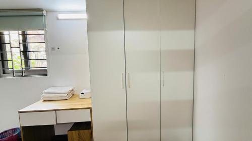 a bathroom with glass cabinets and a desk at Era Apartment Khuc Thua Du in Hanoi