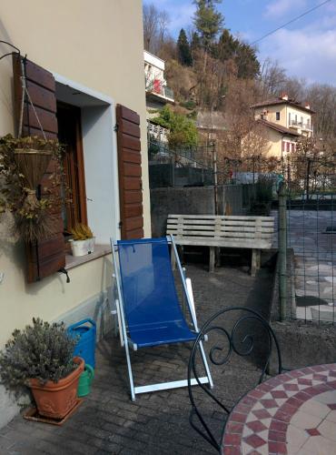a blue chair sitting on a patio next to a building at Casetta next to the Creek Dino Buzzati in Belluno