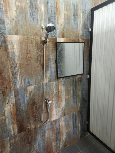 ein Badezimmer mit Dusche und einem Spiegel an der Wand in der Unterkunft Sunset Surf Hostel Siargao in General Luna