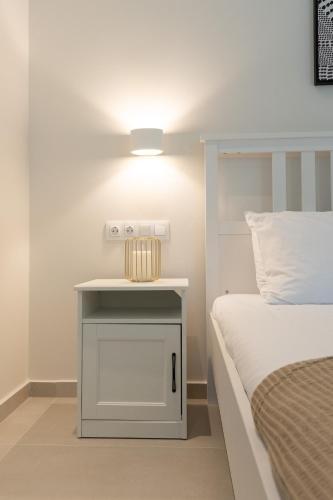a bedside table with a light next to a bed at Sea & Salt Boutique Apartment 4 in Finikounta