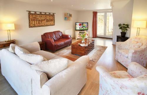a living room with two white couches and a table at The Old Bakery Sleeps 4 in Kingham