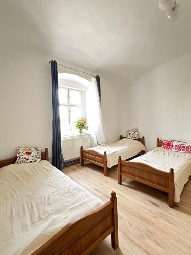 a room with three beds and a window at Templomdomb apartman in Kővágóörs