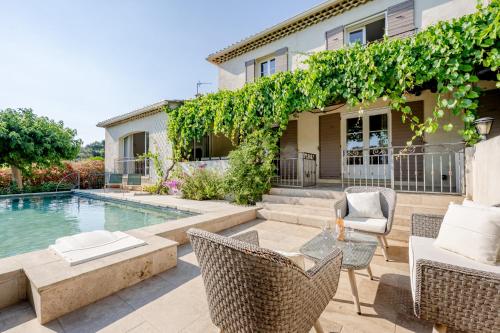a home with a swimming pool and a patio with a table and chairs at Villa Sun7 in Crillon-le-Brave