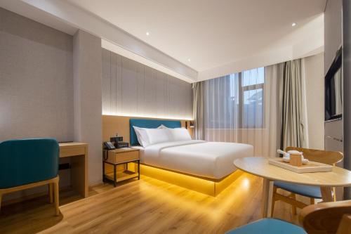 een hotelkamer met een bed en een tafel bij Vyluk Hotel Suzhou Xiangcheng Avenue & Global Harbor in Suzhou