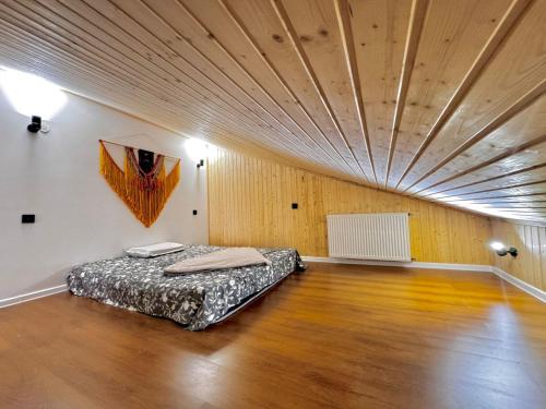 a bed in a room with a wooden ceiling at Maria's Dream House On Vera in Tbilisi City