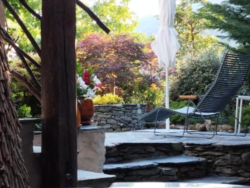 a patio with two chairs and a stone wall at La Bergerie du Miravidi in Bourg-Saint-Maurice