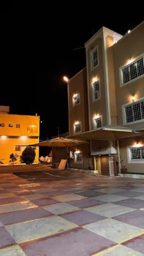 an empty parking lot in front of a building at night at Al Majaridah Hotel in Al Majaridah