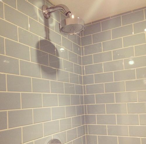 a white tiled bathroom with a shower with a light at 10A Ruston Chambers Free parking, Luxury 2 bedroom city center apartment in St Ives