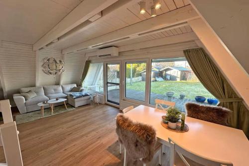 a living room with a couch and a table at Zeltdachhaus mit Zaun in Strandnähe in Damp