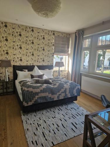 a bedroom with a bed with a blanket and a rug at Hotel Gut Bardenhagen in Bardenhagen