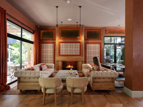 a woman sitting in a living room with a fireplace at Saman Hotel Boutique in Valencia