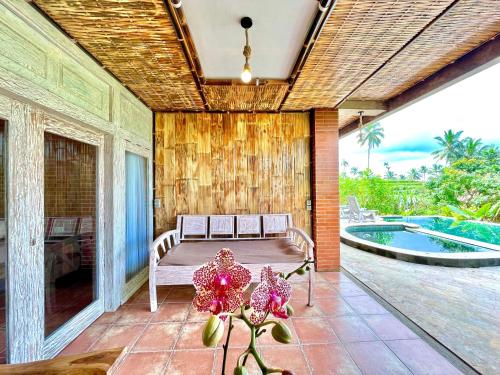 a patio with a bench and a swimming pool at Pondok Is Oke Bamboo Lodge in Licin