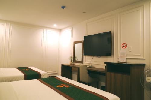 a hotel room with a desk and a television at AS Hotel Đà Lạt in Da Lat