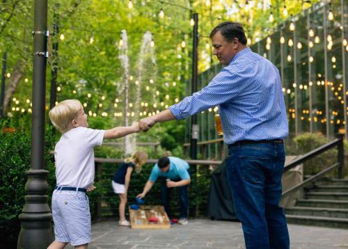 a man holding the hand of a young boy in front of a fountain at Crowne Plaza Atlanta Perimeter at Ravinia by IHG in Atlanta