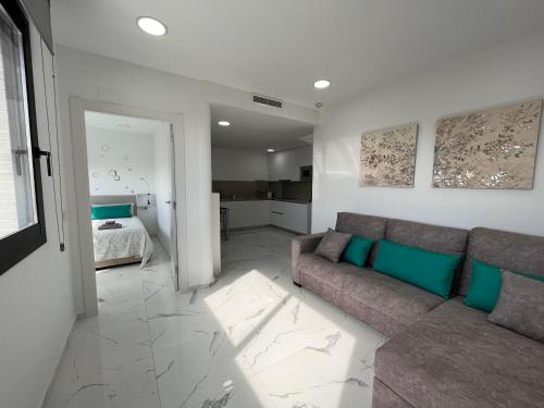 a living room with a couch and a bedroom at Apartamentos Rosa de Abril in Teià