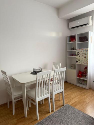 a dining room with a white table and chairs at LS Apartment in Kosovo Polje