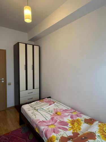 a bedroom with a bed and a dresser in it at LS Apartment in Kosovo Polje