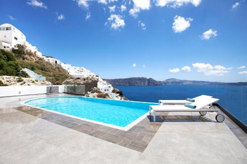 a swimming pool with a lounge chair next to the water at Santorini Secret Suites & Spa, Small Luxury Hotels of the World in Oia