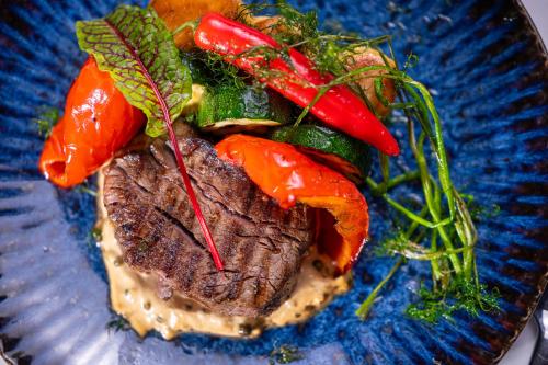 a plate of food with meat and vegetables on it at Hotel Kazimierzówka in Kazimierz Dolny