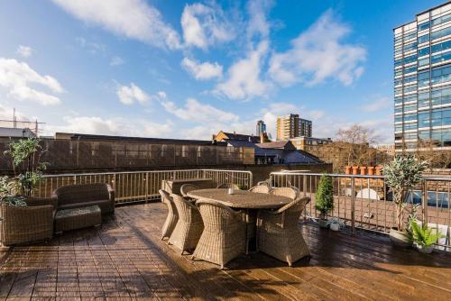 a patio with a table and chairs on a roof at Penthouse Loft apartment with roof terrace Not for events or parties in London