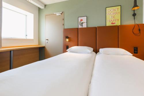 two beds in a small room with a window at Hotel ibis Rennes Centre Gare Sud in Rennes