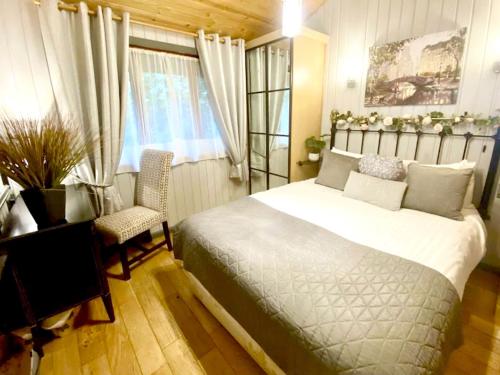 a bedroom with a bed and a desk and a window at Holly Lodge 14 Hot Tub in York